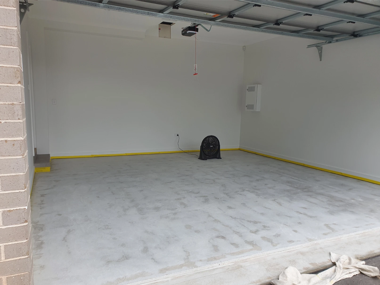 Empty garage interior with yellow trim and fan