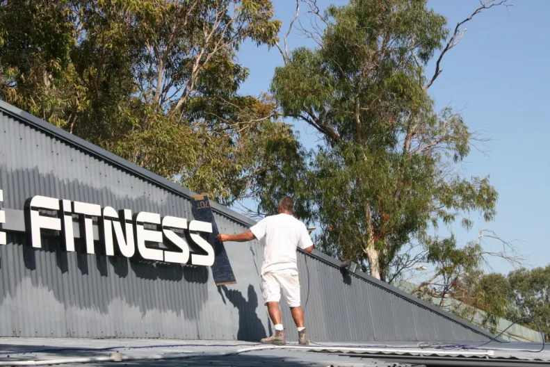 Man walking up ramp to fitness center among trees