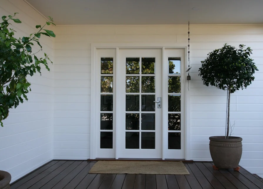 White double doors on house with deck and plant