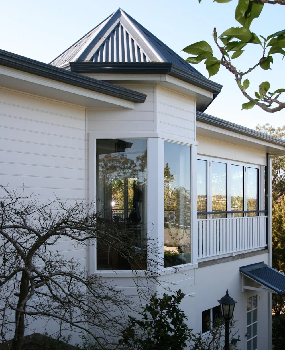 Elegant white house with large windows and peaked roof