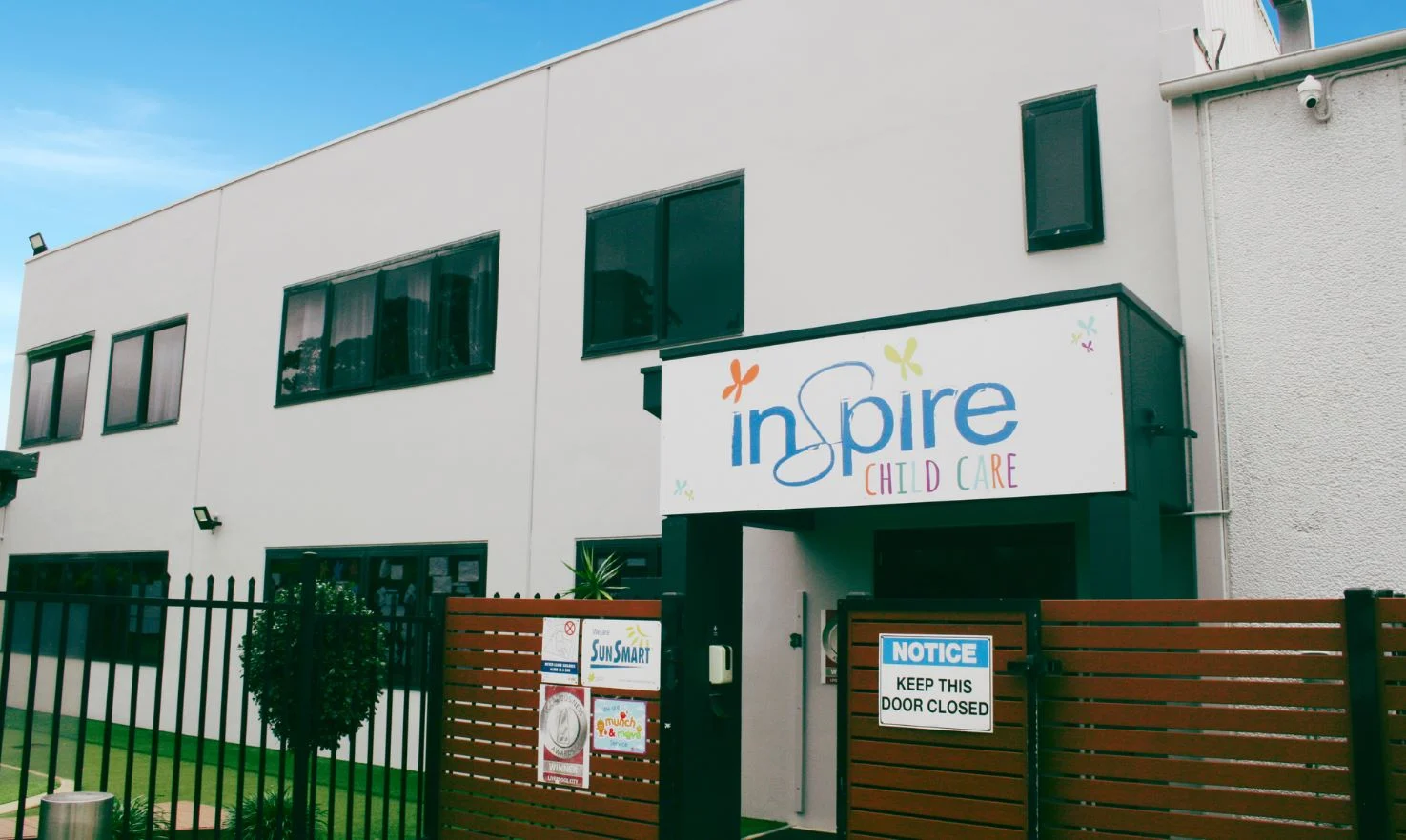 Inspire Child Care center exterior with sign and fence.