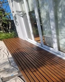 Wooden deck leading to modern glass door entrance