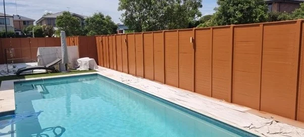 Outdoor swimming pool next to tall orange fence