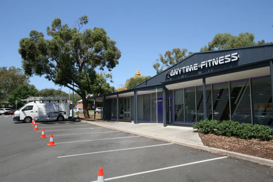 Anytime Fitness gym exterior with parking and trees