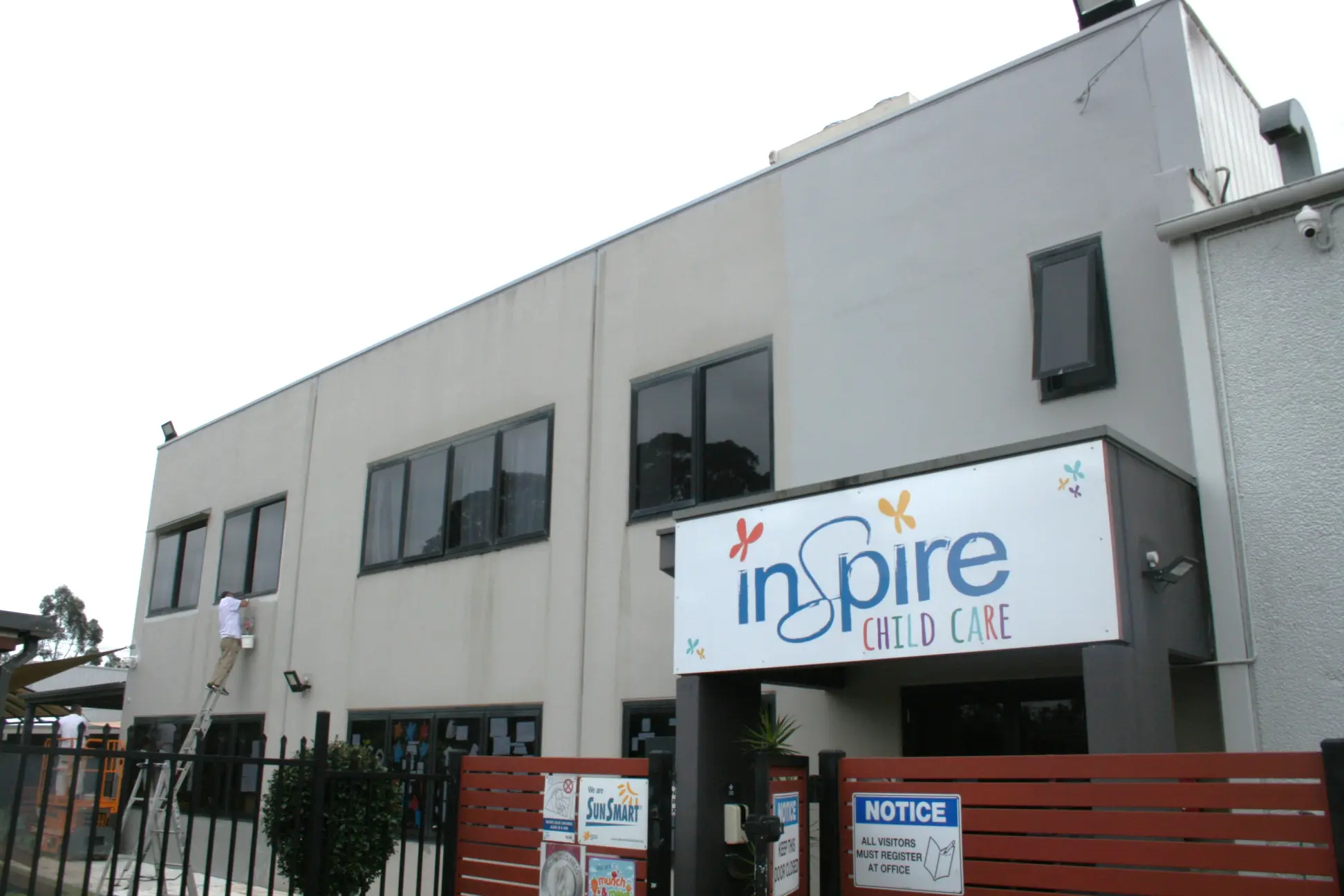 Inspire Child Care center exterior with worker on ladder