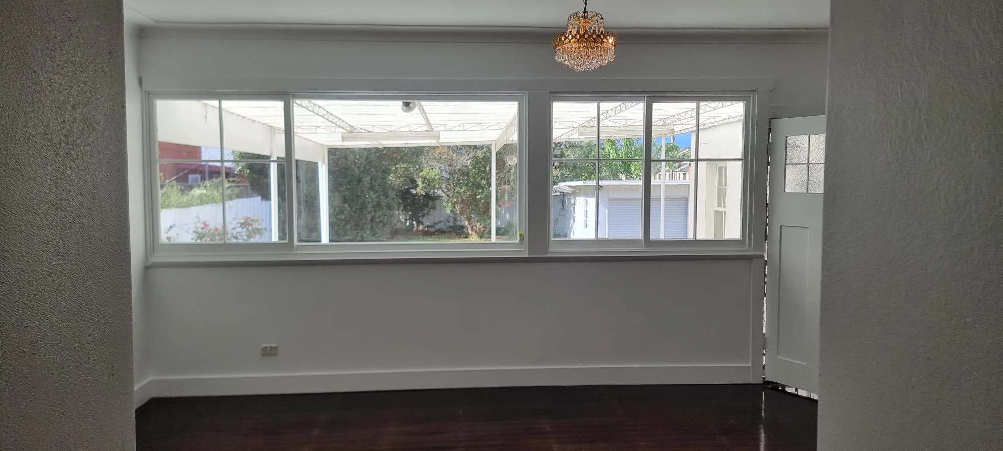 Empty room with large windows and chandelier