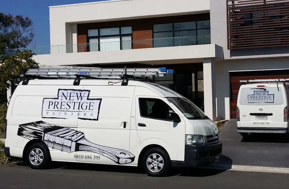 Painting service vans parked in front of modern house