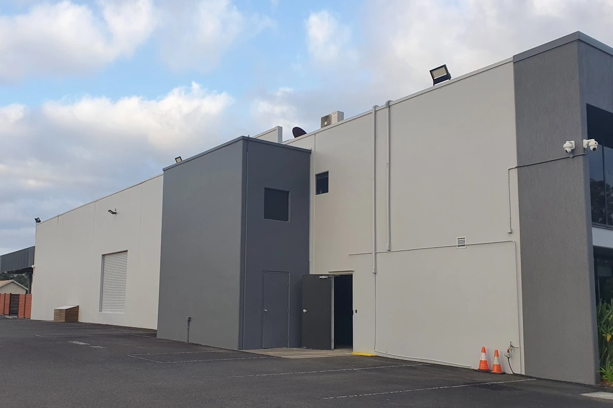 Modern industrial warehouse exterior with cloudy sky