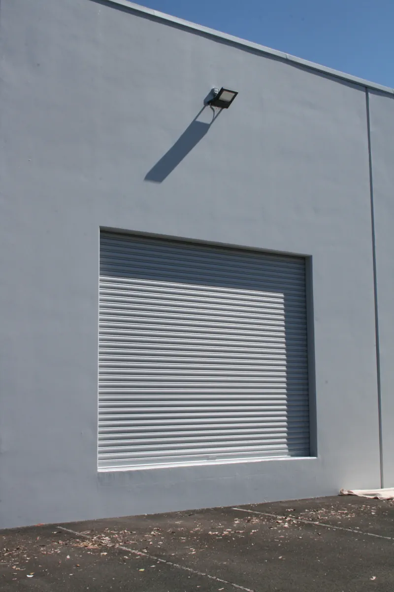 Wall-mounted security light casting shadow on building