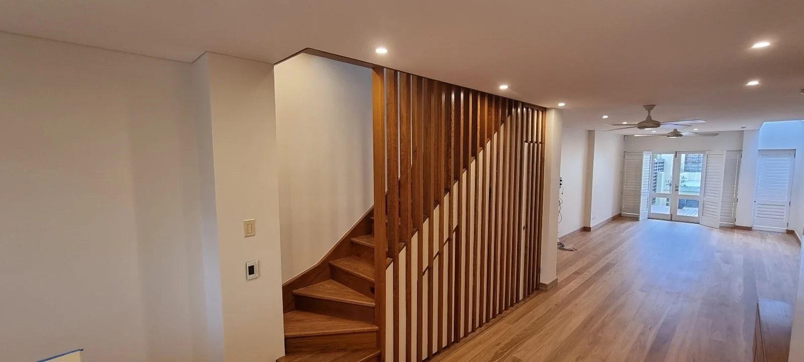 Modern interior with wooden stairs and spacious living room